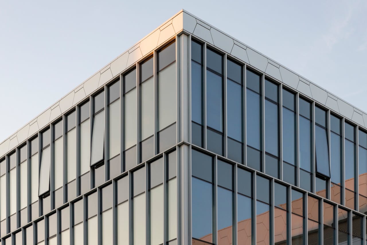 Contemporary building with glass facade reflecting sunset in Vilnius, Lithuania.